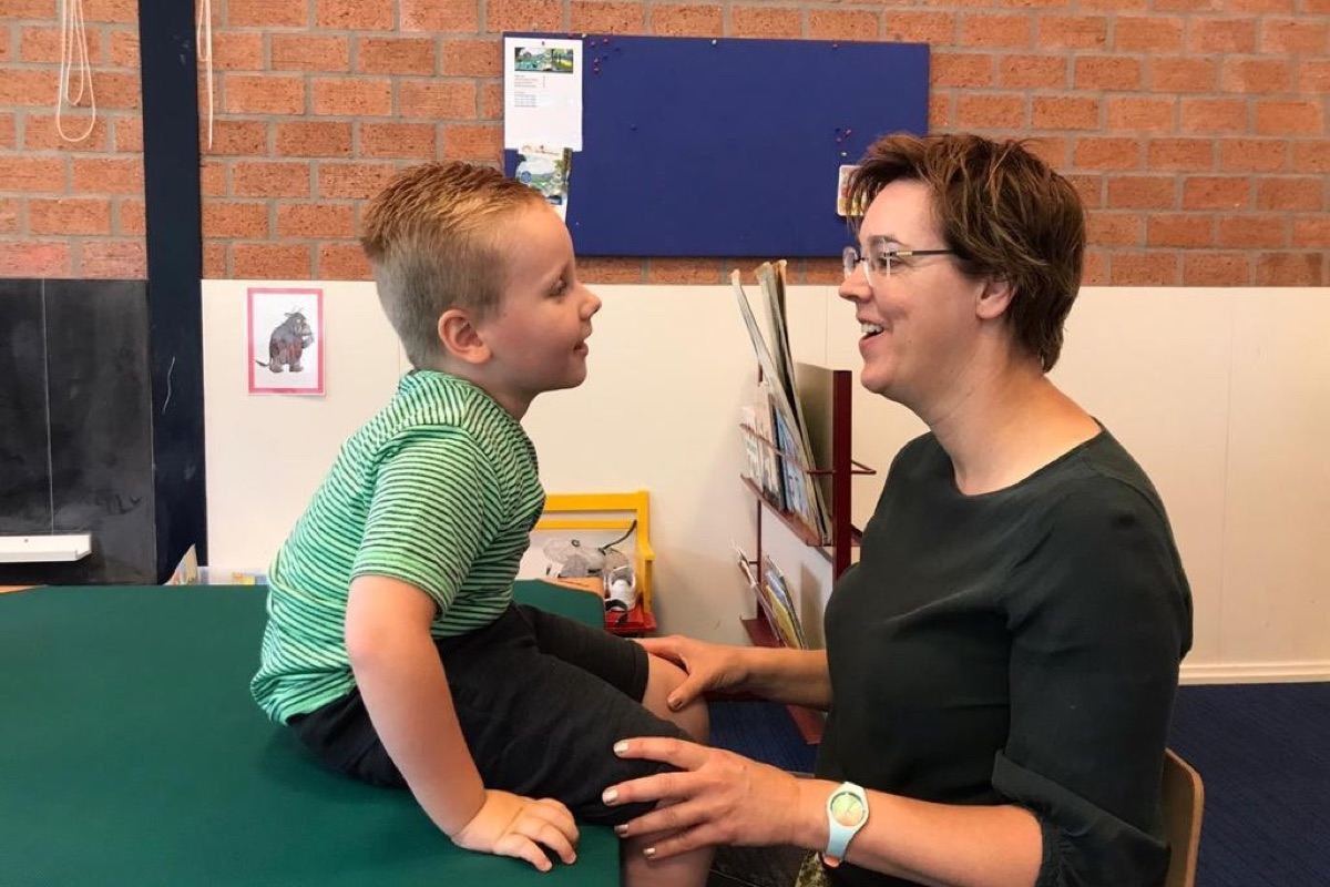 Kinderfysiotherapeut en kind werken samen aan bewegen en balans