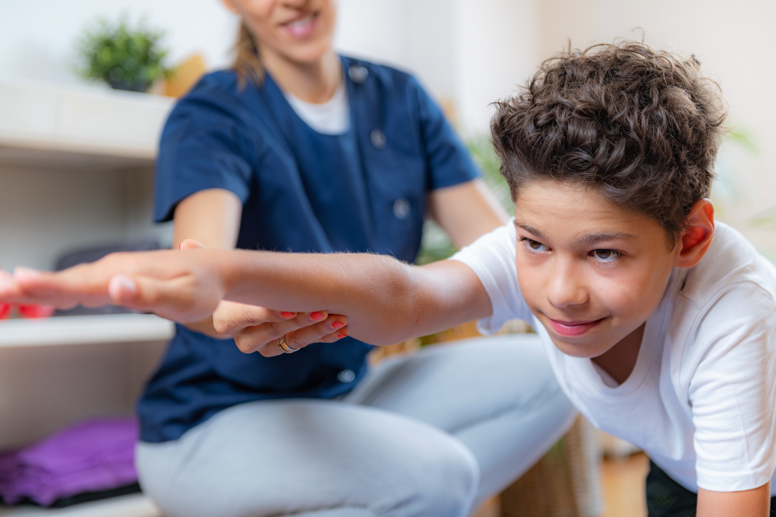Jong kind oefent bewegen tijdens kinderfysiotherapie